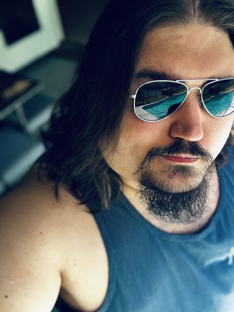 AJ Hanson's Headshot - Him staring at the camera while wearing sunglasses