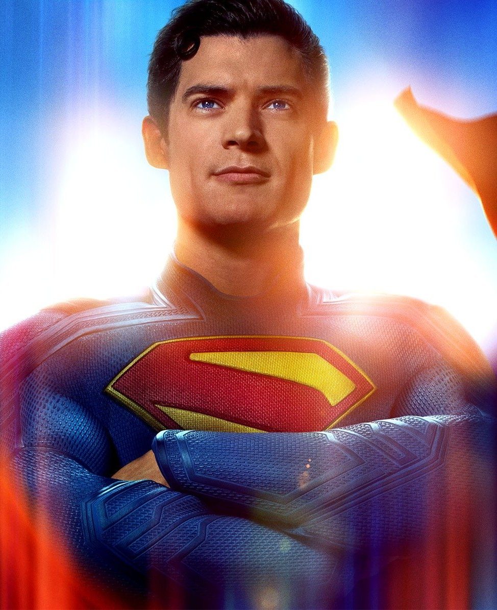 The 2025 Superman movie keyart with Superman looking out at the viewer and a flashy blue and red background that implies flying behind and around him